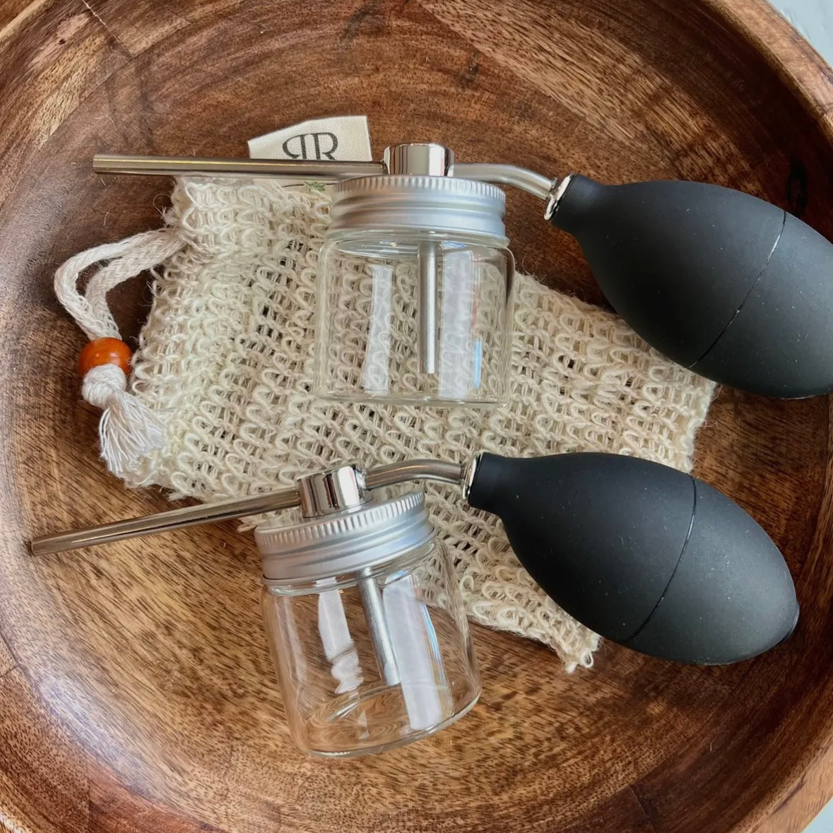 Two glass jars with metal lid and silicone spray pump.