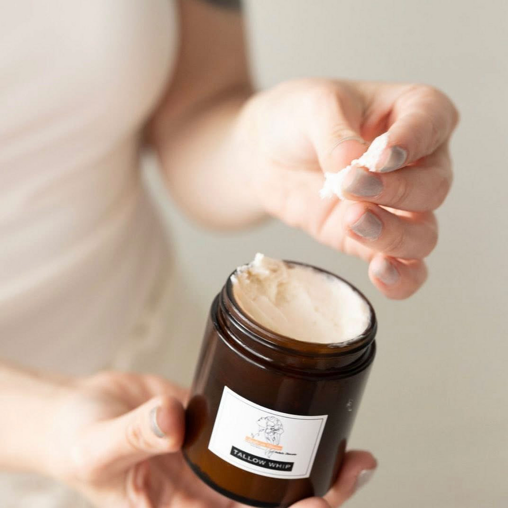 Hand holding tallow whip to show consistency. 