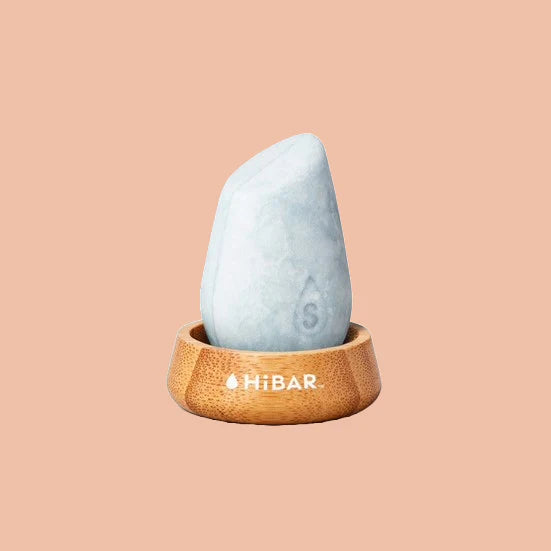 Hibar solid shampoo bar sitting in bamboo shower holder.