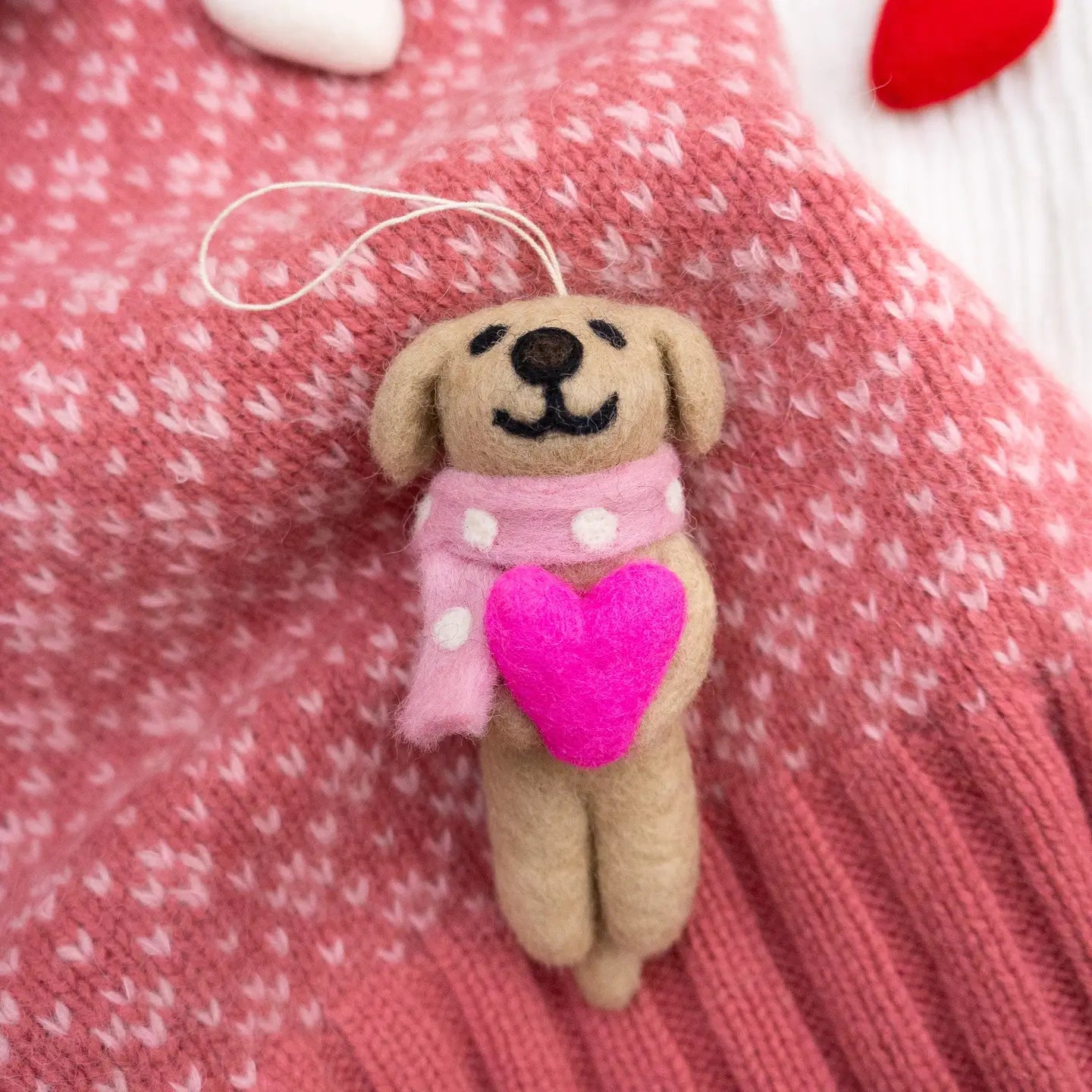 Small brown dog plush toy with a pink heart and scarf.